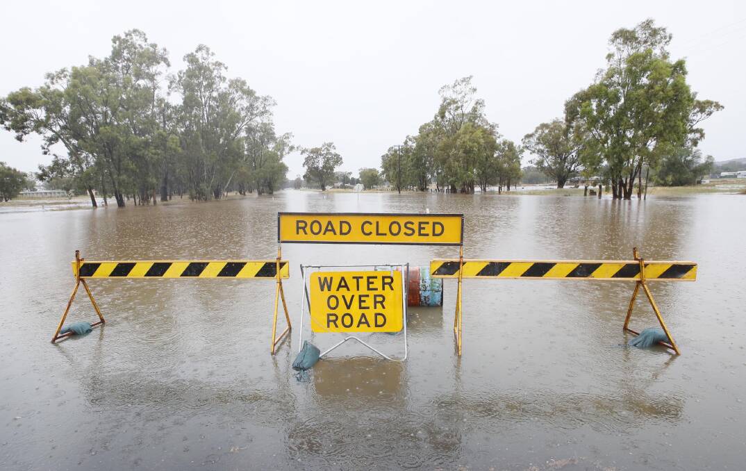 STAY AWAY: Looking down King Street from Yerong Street in The Rock, where the road was closed yesterday after constant rain saw it submerged. The rain was expected to ease overnight and clear today. Picture: Les Smith