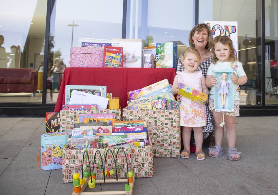 125 YEARS: Phoebe Richardson, 2, Kerrie Harris, and Olivia Richardson, 4, proudly present the gifts to Wagga Base Hospital. Picture: Ash Smith 