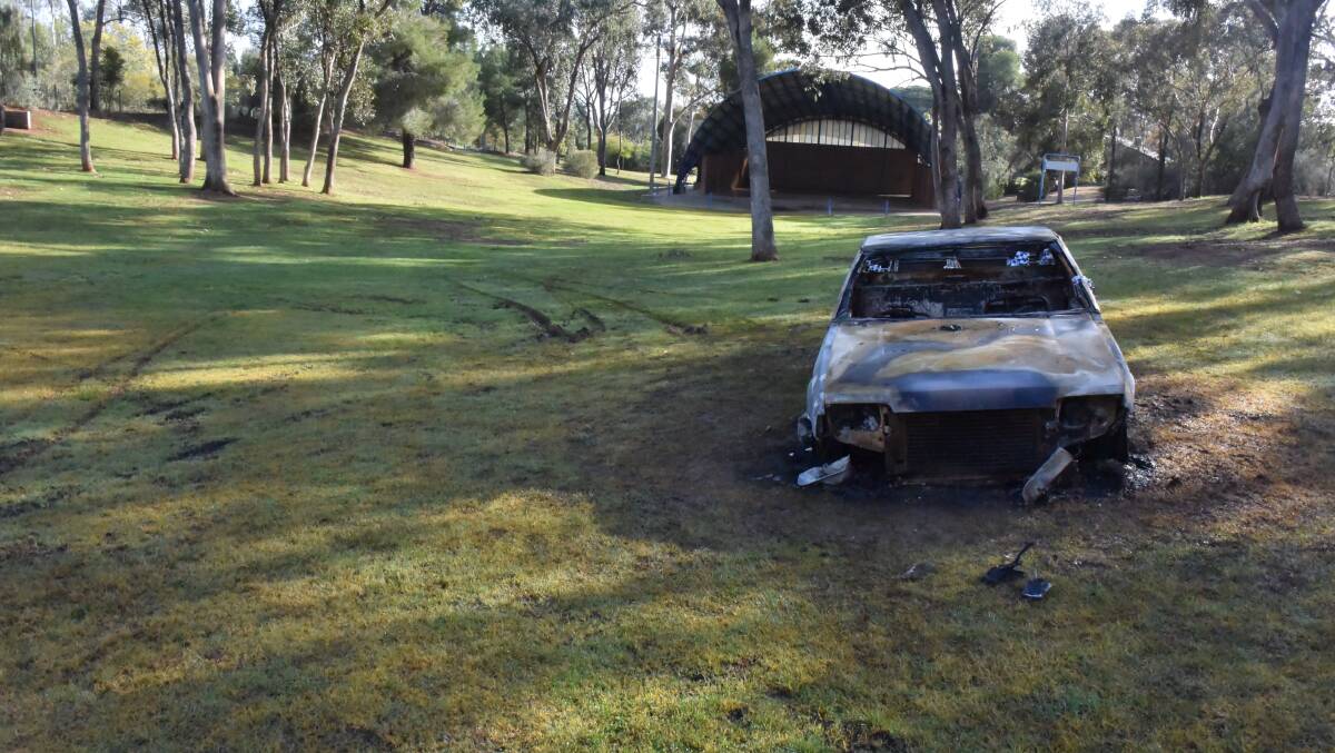 TORCHED: The smouldering remains of Wagga resident William George's Ford Falcon. Mr George has called for tougher penalties for young thieves.
