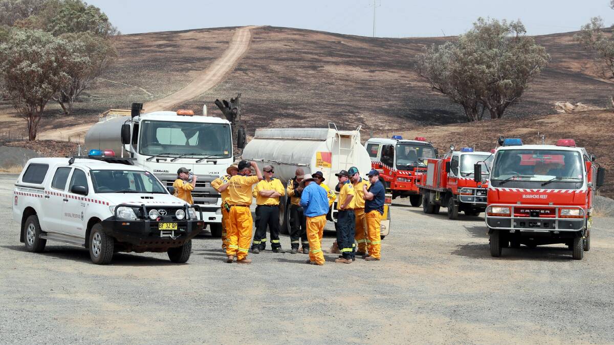 PREPARATIONS: As weather conditions deteriorated, Rural Fire Service volunteers did what they could to prepare properties on the Snowy Mountains Highway. Picture: Les Smith