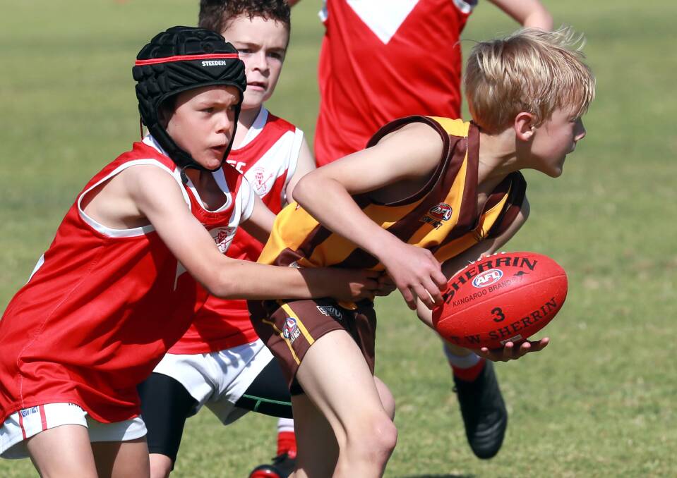 JUNIORS PRESSURE: East Wagga-Kooringal's Brayden Slater is under pressure from Collingullie-Glenfield Park's Hunter Nicoll in their under 12s game early last season. The under 12s and under 14s could both be dispensed with in Wagga and District Juniors this year. Picture: Les Smith