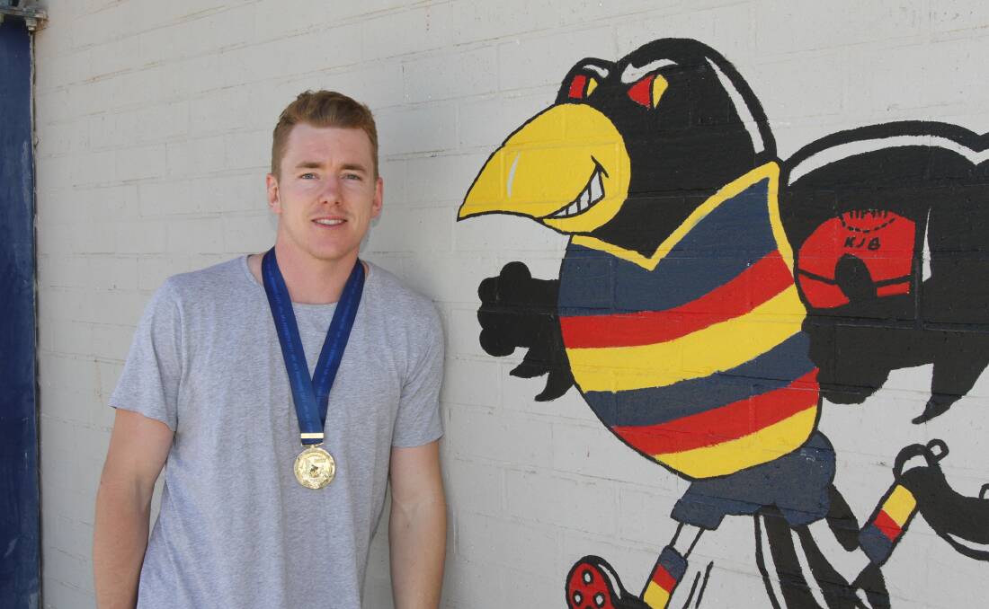 Jacob Townsend with his AFL premiership medal at the home of Leeton-Whitton Crows.