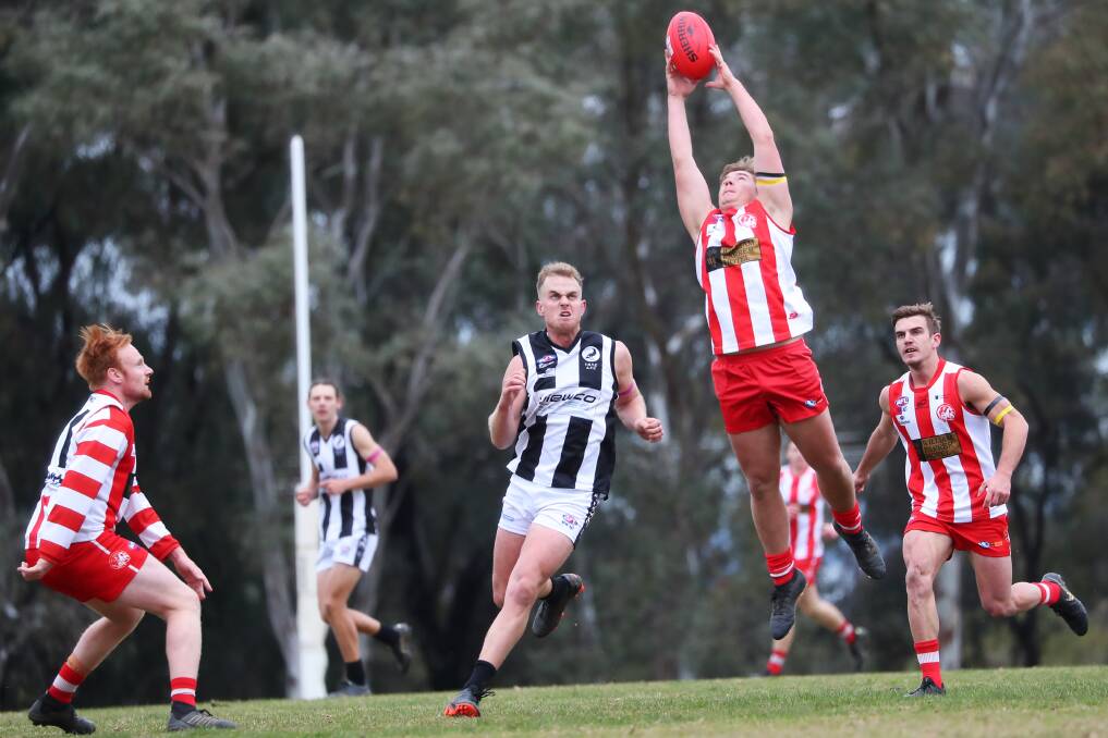 CSU's Will Thorp goes up for a mark as TRYC's Jim Carroll closes in. Picture: Emma Hillier