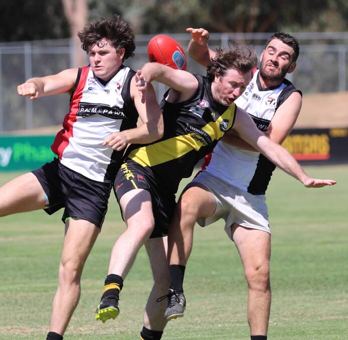 OUTNUMBERED: Tigers' Matt Noonan is up against it in this contest with North Wagga's Lachie Robertson and Brendan Byrnes as the clubs' reserve grade sides do battle at Maher Oval. Picture: Les Smith