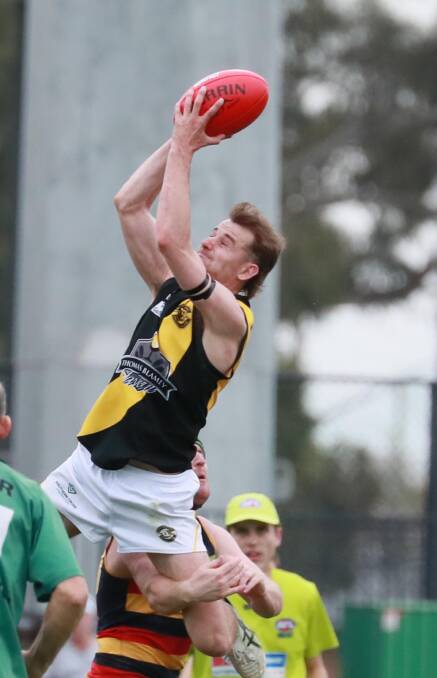 SOARING: Tigers' best-on-ground Shaun Driscoll gets airborne in their AFL Riverina Championship win against Leeton-Whitton. Picture: Les Smith