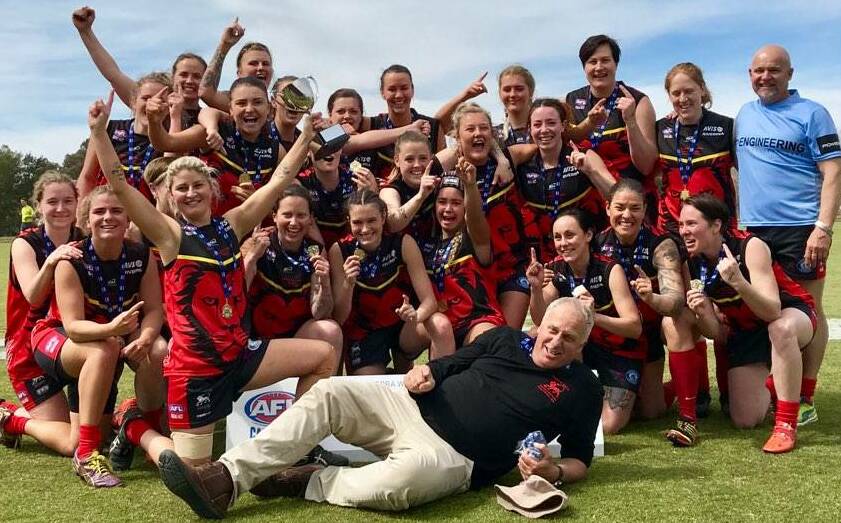 HAPPY DAYS: Riverina Lions and coach Jed Lawton (front) after their breakthrough premiership success in 2018.