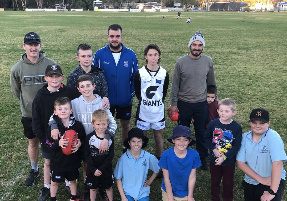 EXCITEMENT: TRYC co-president David Pieper (back, left), forward Shannon Williams backm centre) and co-coach Heath Russell (back, right) with some of the Magpies juniors at training on Thursday night. 