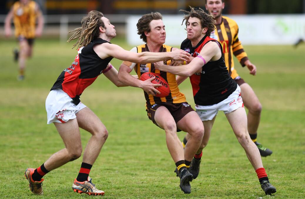 UNDER PRESSURE: East Wagga-Kooringal's Harrison Leddin is sandwiched by Bombers Jackson Sanbrook (left) and Damian O'Donoghue in the Hawks' heavy loss. 