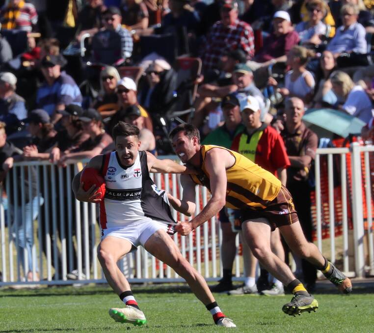 CROWD QUERY: Spectators shoulder to shoulder at the Farrer League grand final watching North Wagga's Ben Alexander try to shake off the Hawks' Jacob Tiernan. Picture: Les Smith