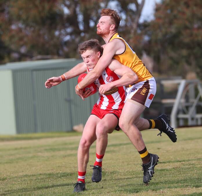 GRUELLING CONTEST: CSU's Andrew Corrigan is wrapped up by Hawks defender Hayden Nelson in their round nine game at Peter Hastie Oval on Saturday. Picture: Emma Hillier