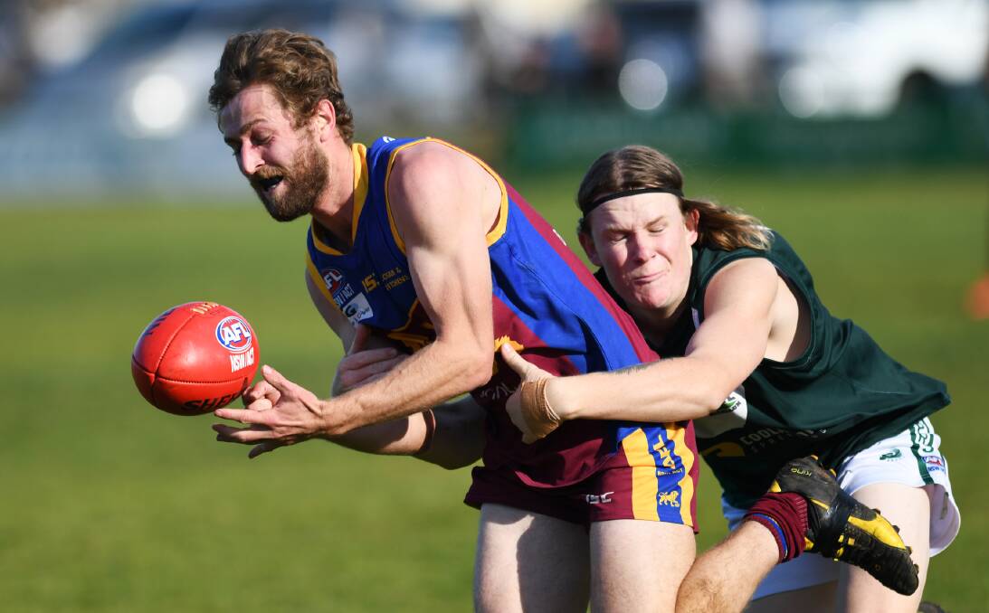UNDER PRESSURE: GGGM's Jesse Lander tries to fire out a handball despite a tackling Jack McPherson in Coolamon's win at Ganmain. 