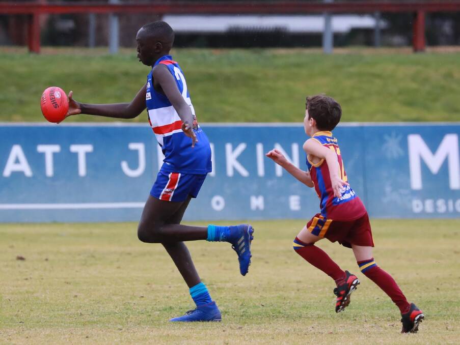 MIS-MATCH: Ganmain-Grong Grong-Matong's Milton McPherson has his work cut out trying to keep up with Turvey Park's Lado Kuron in the Under 10s at Maher Oval last Sunday. Picture: Les Smith