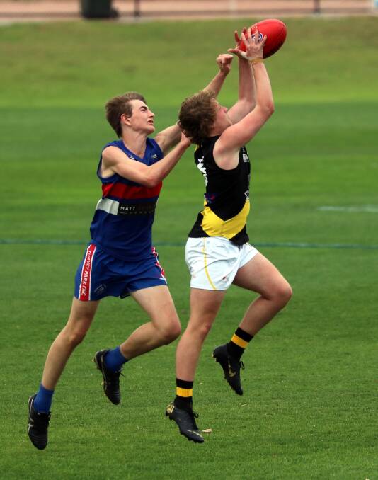 ON THE RISE: Turvey Park's Cooper Harmer leaps to spoil Tigers' Jeremy Lucas in their Under 17.5 grand final last week at Narrandera last week. Picture: Les Smith