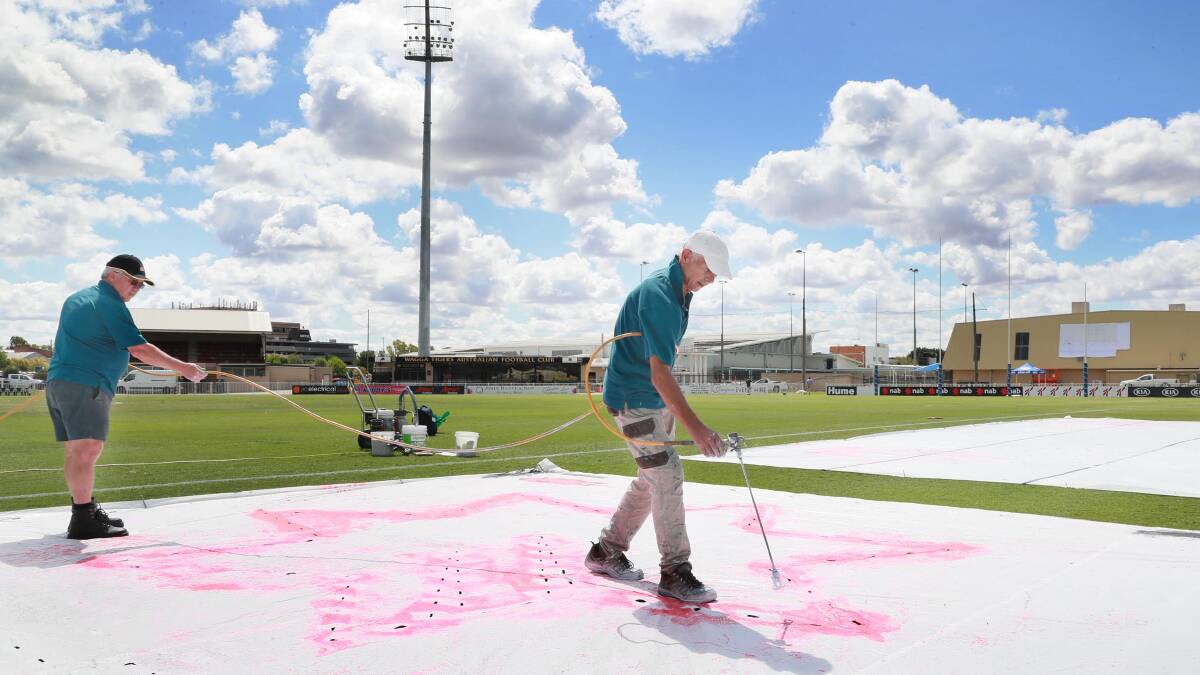 FINISHING TOUCHES: Roy Phillips (left) and John Kuhn from GrassFX Canberra finalising the look and logos on the surface at Robertson Oval on Friday afternoon. Picture: Les Smith