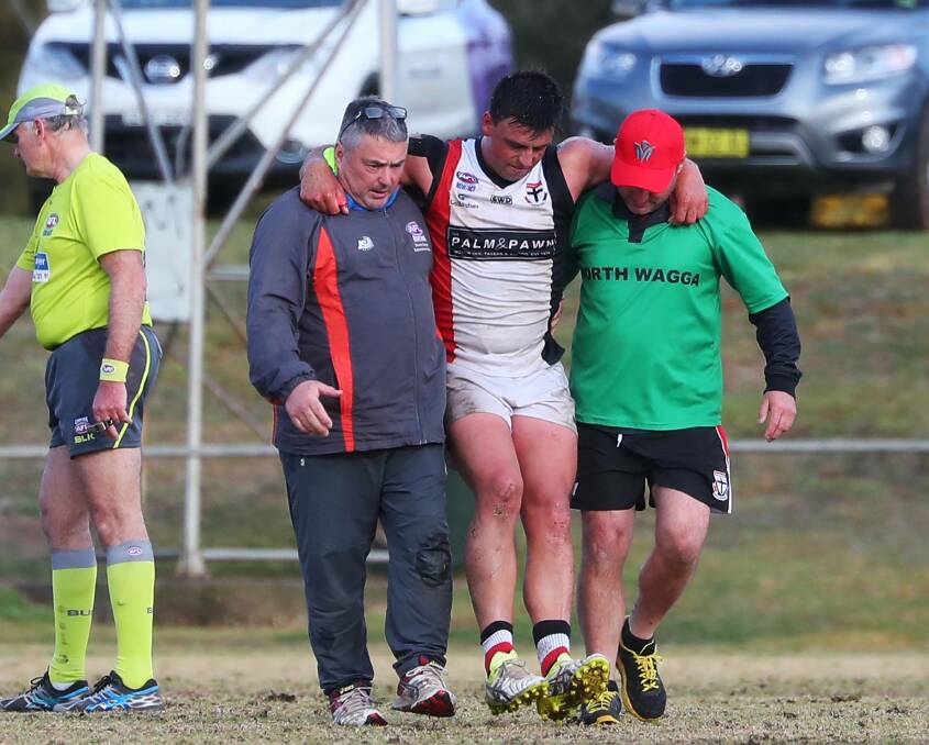 BOLD BID: North Wagga captain Ned Mortimer is helped off the ground in the fourth quarter of last week's loss to Marrar. Picture: Emma Hillier