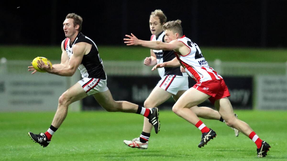STRETCHED OUT: North Wagga defender Luke Walsh gets out in front of CSU's Andrew Corrigan on Saturday night at Robertson Oval. Picture: Les Smith
