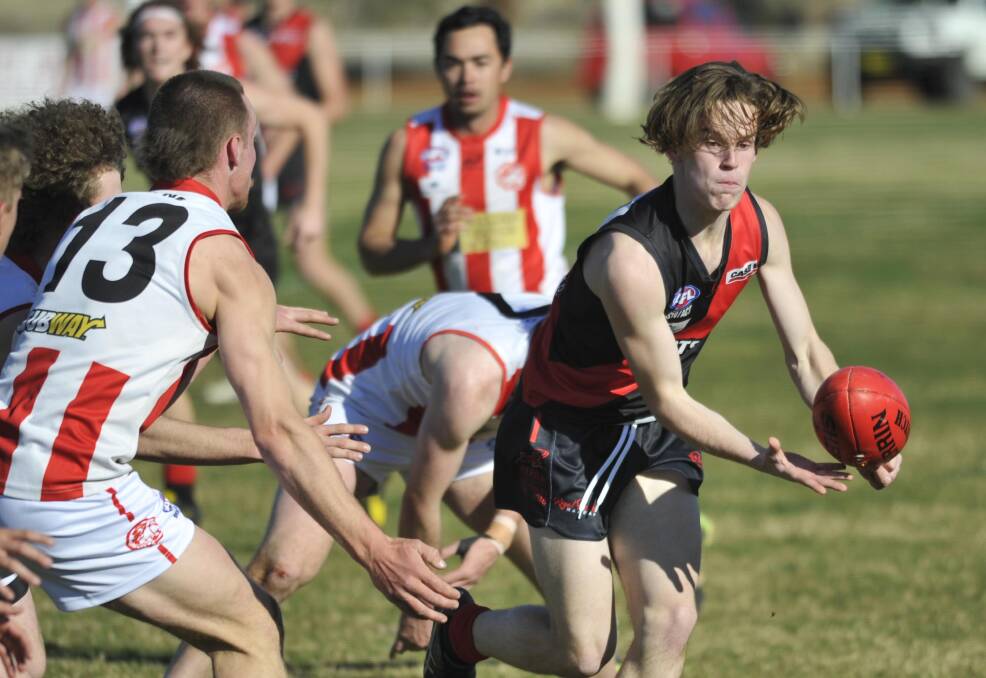 ON THE MOVE: Marrar's Toby Lawler drives the Bombers forward in the first quarter at Langtry Oval on Saturday as CSU's Max Hanrahan closes in. 
