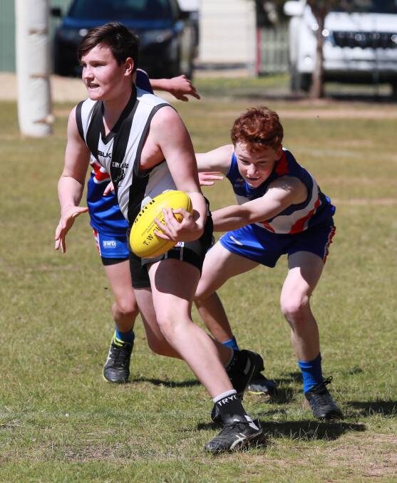 ASSESSING OPTIONS: The Rock-Yerong Creek's Harry Hopkins looks for a teammate as Turvey Park midfielder Ben Quilter tries to hang on. Picture: Les Smith