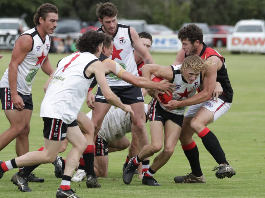 NO WAY OUT: North Wagga's Bailey Clark is wrapped up by Marrar ruckman Nick Molkentin in the Bombers' win at McPherson Oval on Saturday. Picture: Madeline Begley