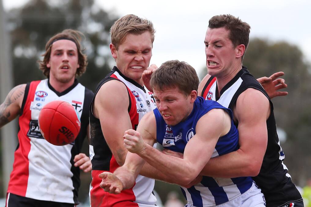 UNCOMFORTABLE SITUATION: Temora's Sam Jensen gets a handball away at McPherson Oval despite attention from North Wagga's Brayden Skeers and Tom Bennetts (right). Picture: Emma Hillier