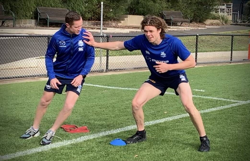 Turnbull working with former North Melbourne forward Ben Brown.