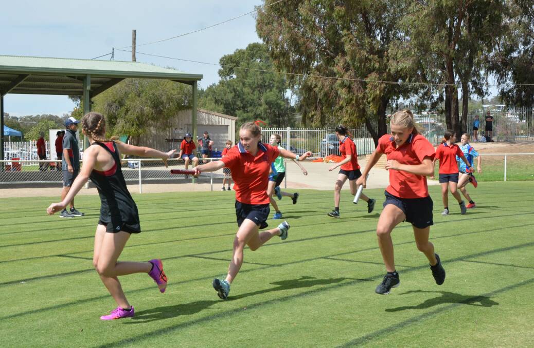 RELAY CHANGE: Emma Suckling passes the baton to Ella Hale in the 14 years girls relay, with Mischa Garrod on the inside, at Kildare Catholic College athletics carnival. Picture: Contributed