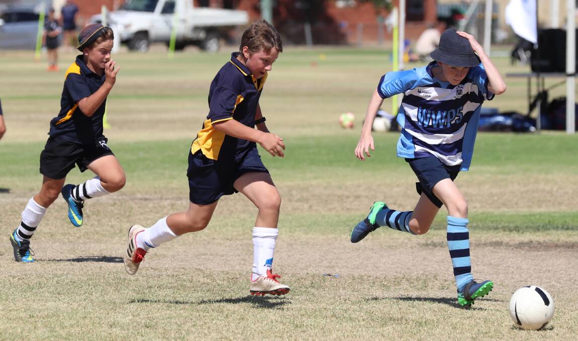 UNDER PRESSURE: Jude Passlow from Wagga Public School finds The Rock Central's Robbie Blacklock closing in at Duke of Kent Oval during Friday's soccer gala day. Picture: Les Smith