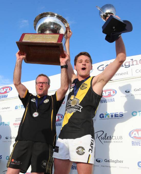 Tigers coach Troy Maiden and former captain Nick Ryan lift the trophies after the grand final win against Griffith. Picture: Les Smith