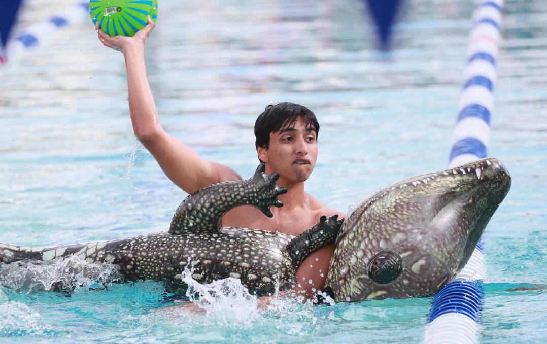 CARNIVAL ATMOSPHERE: Harshil Rawal braves the wildlife and the water in one of the novelty events at the Wagga High School swimming carnival. Picture: Les Smith