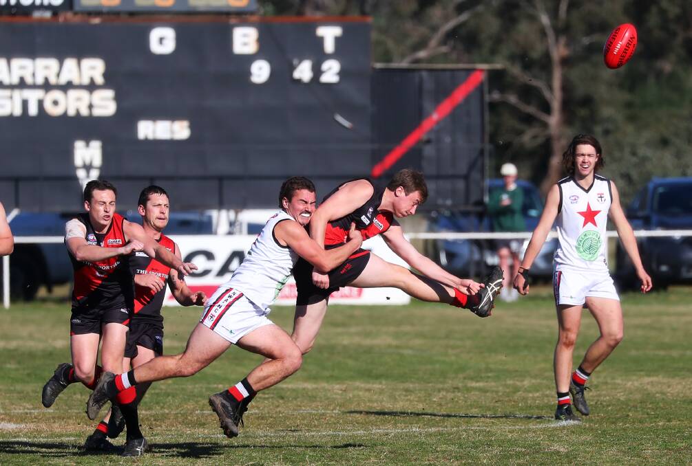PRESSURE GAME: Marrar's Harry Reynolds gets a kick away despite Jack Flood's tackle in the Bombers' five-goal win against North Wagga. 