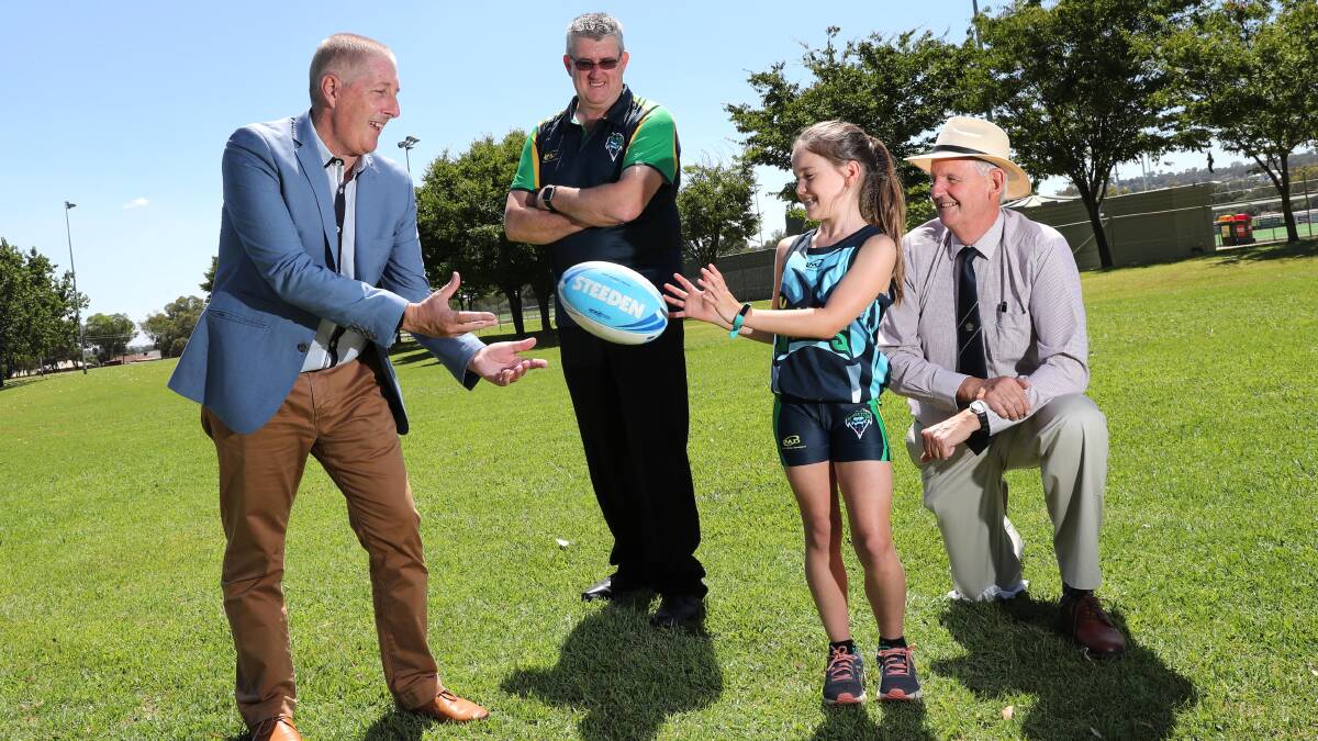 BIG NEWS: NSW Touch general manager, Dean Russell (left) fires out a pass to young player, Georgie Hayes, 9,  as Wagga Touch Association president Chris Dolahenty and Mayor Greg Conkey watch on at Tuesday's Junior State Cup announcement in Wagga. Picture: Les Smith