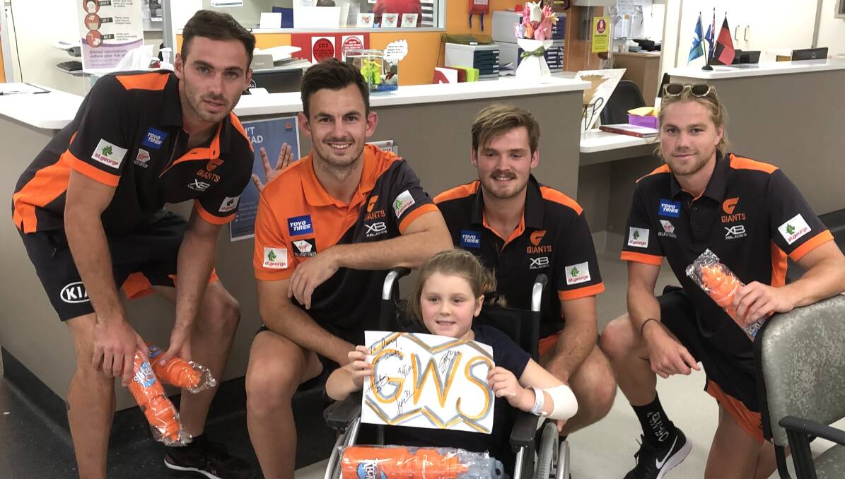 WELCOME VISIT: Tumbarumba's Chloé Foster, 6, catches up with Greater Western Sydney Giants (from left) Jeremy Finlayson, Zach Sproule, Matt Flynn and Harry Himmelberg at Wagga Base Hospital. Picture: Peter Doherty