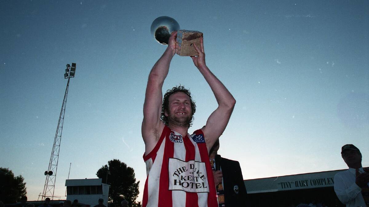 Matt 'Jiffy' Carroll with the spoils of victory. The premiership cup in his first season as a senior coach.