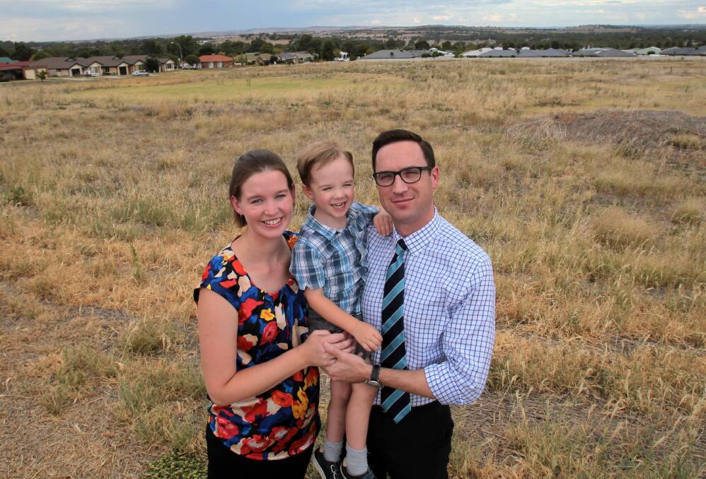 Estella residents Christina, Oliver and Graham Cotter at the site for a new school in March, one of many families that could benefit from soccer grounds closer to home. Picture: Les Smith