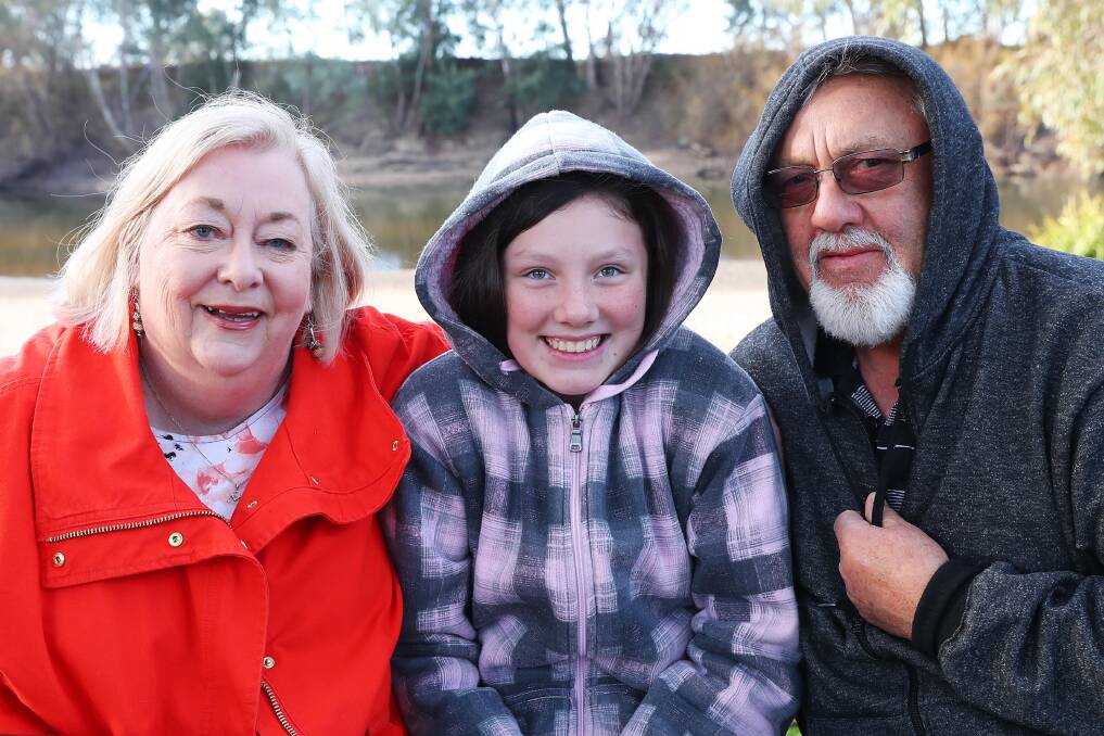 Rugged up: Joy and Ray Cooper, are braving the winter holidays with their granddaughter, Isabella Cooper, 11, at Wagga Beach Caravan Park. Picture: Emma Hillier