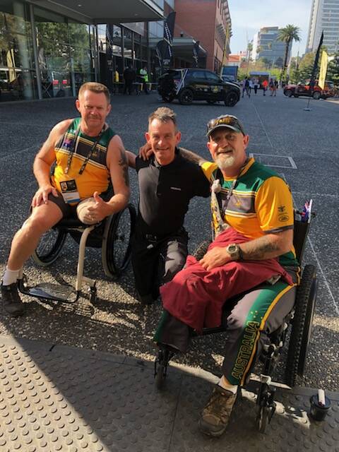 In gear: Mobility technician Shane Cattanach with two members of the Australian wheelchair rugby team at the games in Sydney. Picture: Supplied 
