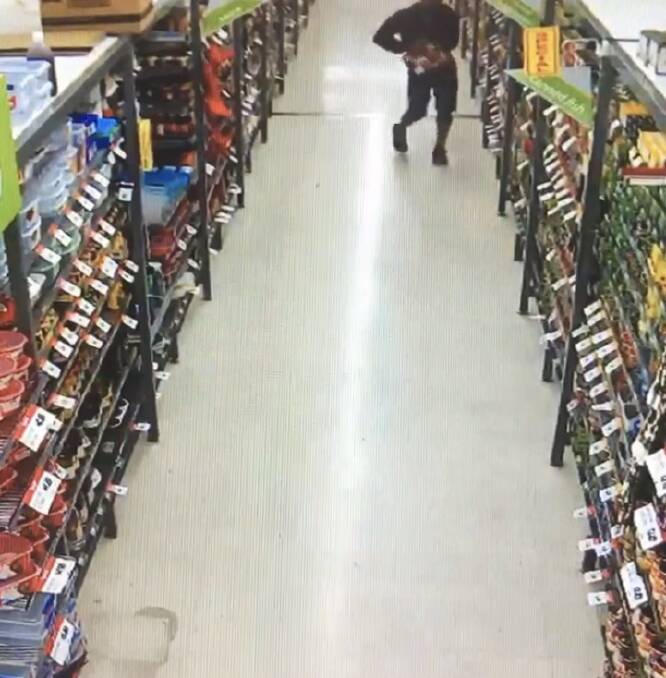 CCTV still: A man putts a meat tray down in pants at Lake Albert Foodworks.