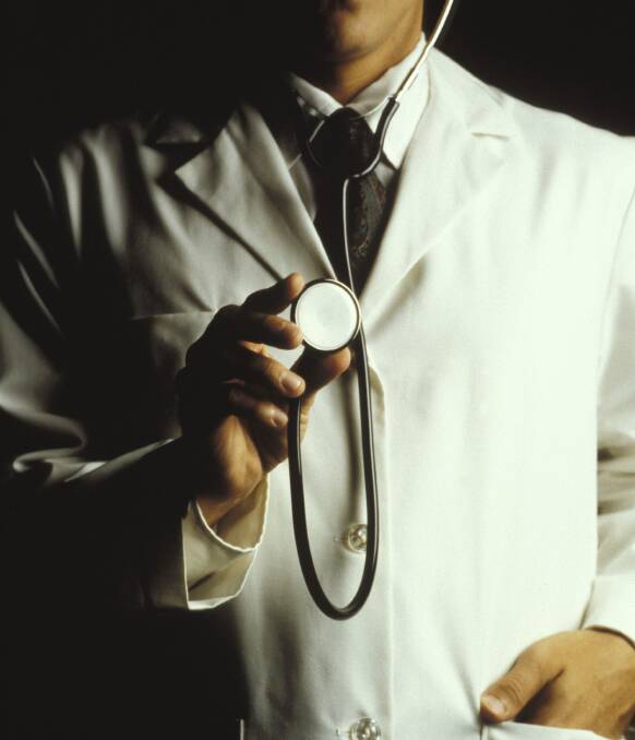 A doctor in a white lab coat holding up a stethoscope.