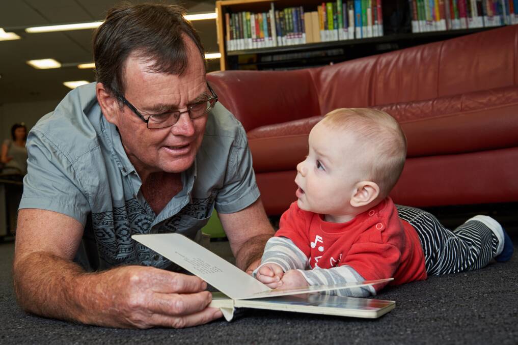 READING JOY: Max and his grandfather Geoff discovering the magic of books available to enjoy free at the library. Picture: Michael Frogley