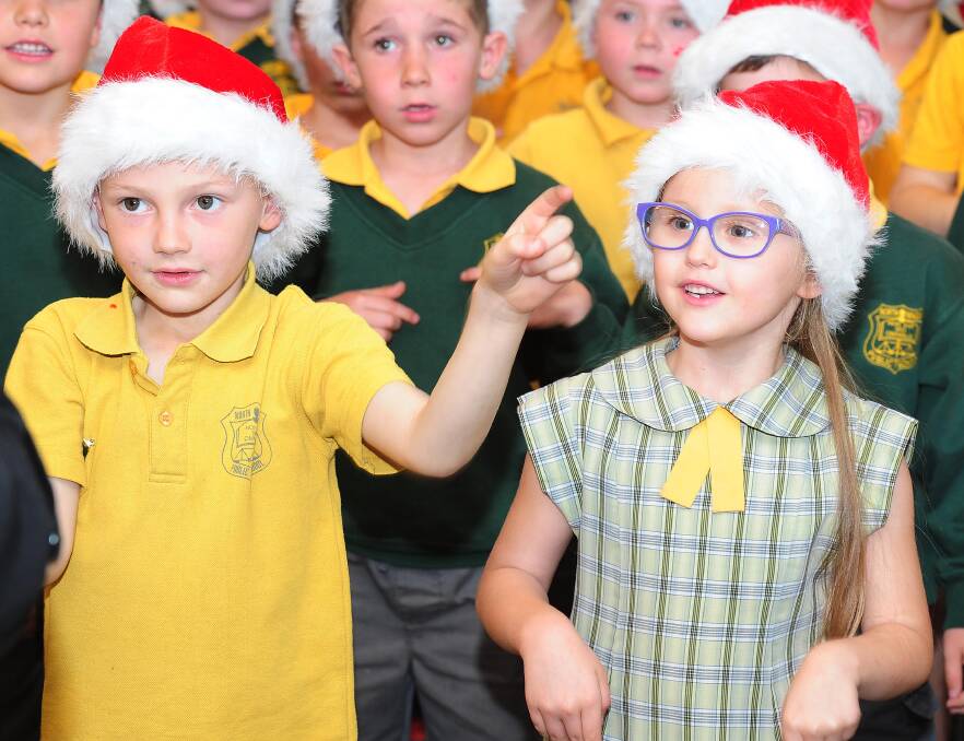 FESTIVE: Kevin Bjorklund and Emmerson Green sing in North Wagga Public School choir at the Christmas Wishing Tree unveiling at K-mart. Picture: Kieren L Tilly