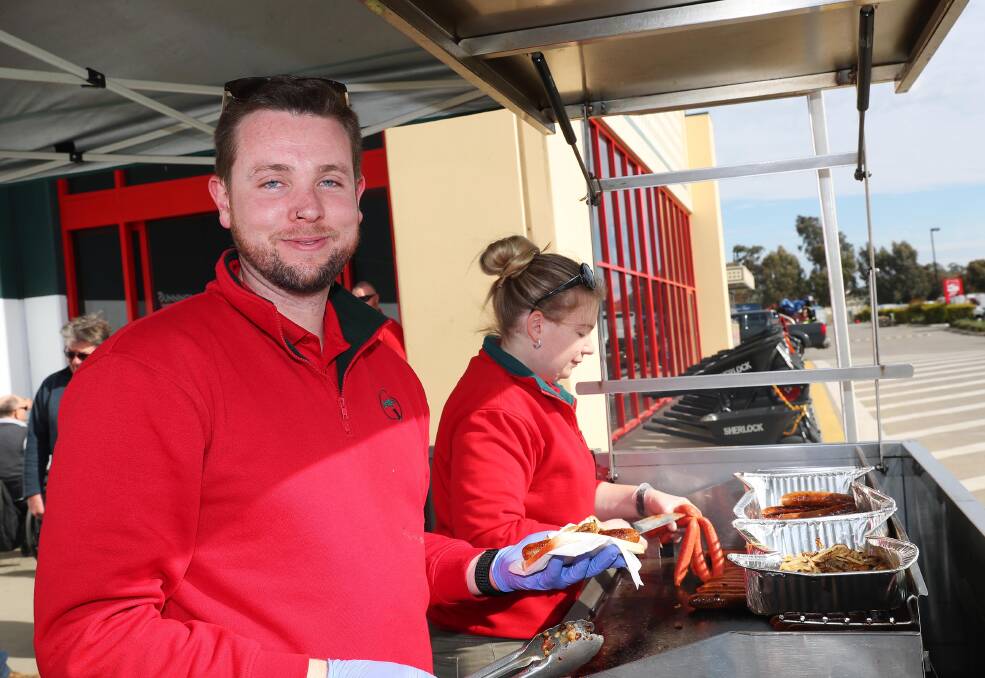 GOOD CAUSE: Thomas Moriarty and Lisa Holgate man the barbecue at Friday's Bunnings Buy a Bale sausage sizzle. Picture: Emma Hillier