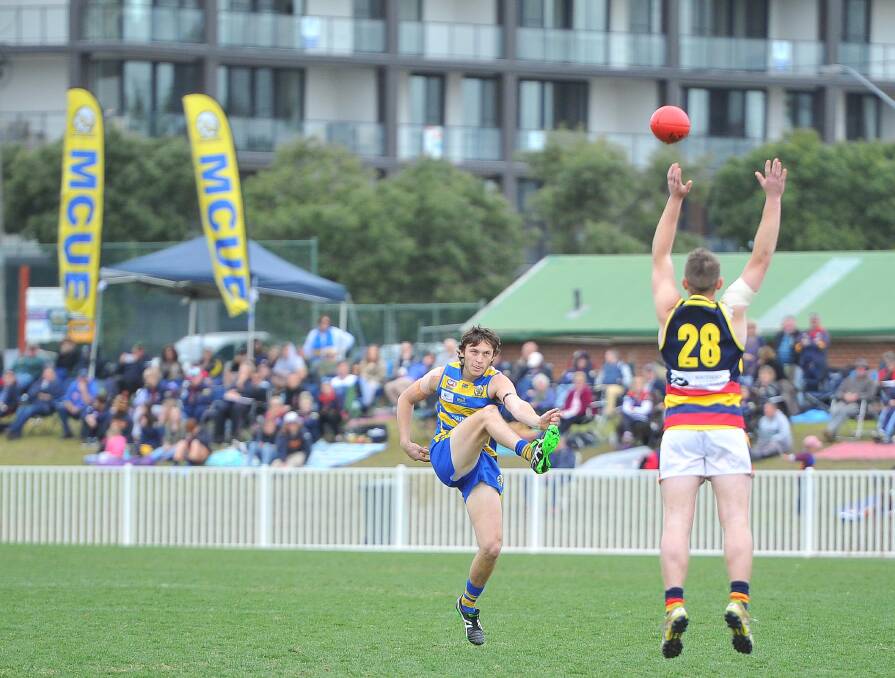JUMP: MCUE Jacob Whitley kicks over James Nancarrow for Leeton during the Riverina Football League at Robertson Oval. Picture Kieren L Tilly