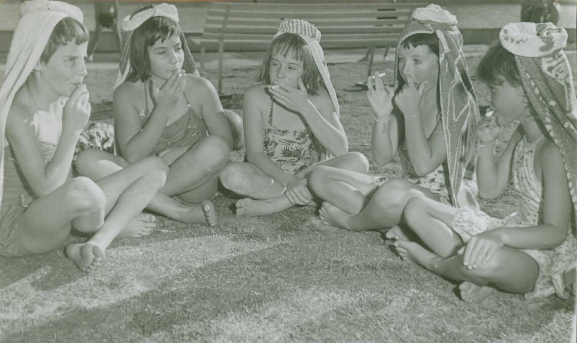 MOMENT IN TIME: Young girls mimicking adults as they “puff” on lolly cigarettes at the Wagga Pool in the 60s – something you’re unlikely to see today with 21st century attitudes to smoking. Picture: Contributed