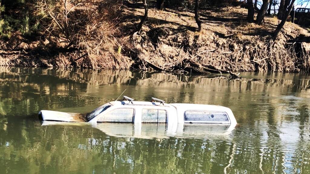 OUT OF PLACE: A car sits in the river. 