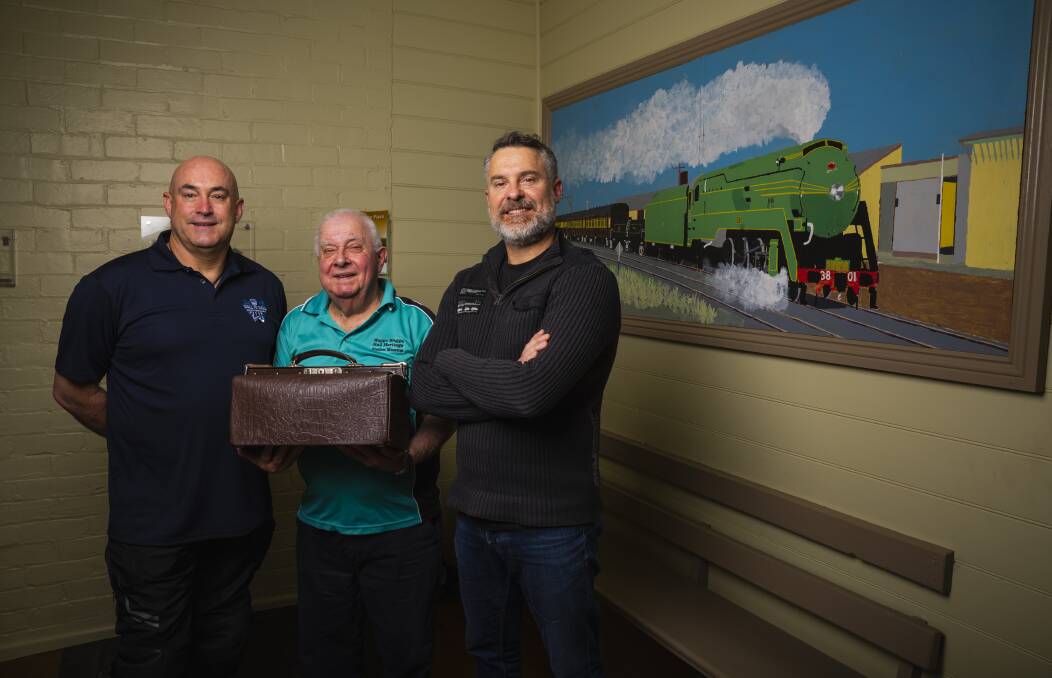 Gerard, Peter and Graeme Simpfendorfer in the waiting room of the Henty railway station. Peter is holding a Gladstone bag which his father Fred took to work each day. Picture by Ash Smith 