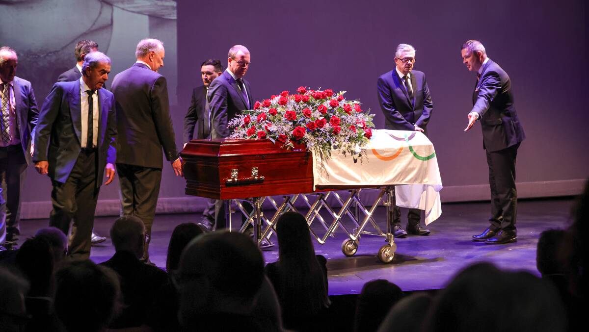 Last ride: Pall bearers move to wheel the casket of Dean Woods off the stage of the Wangaratta Performing Arts Centre.
