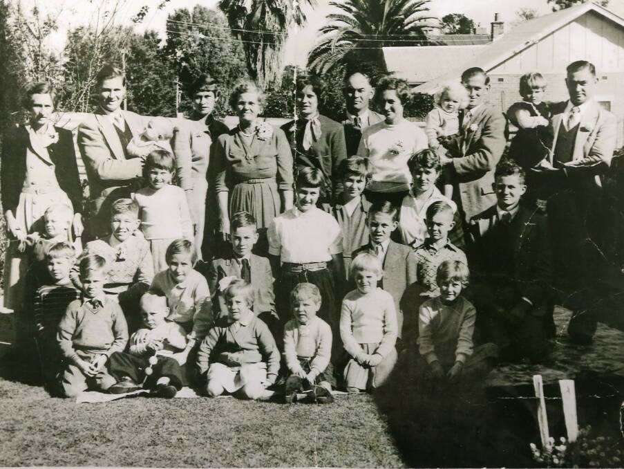 A family photograph that shows Judith Larkins as a girl and her mother Dorothy. The former is in the centre row and the latter is behind her in a white jumper.