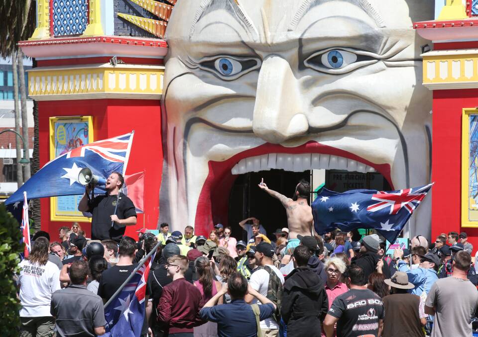 Not so amusing: Far right extremists rally outside the entrance to Luna Park in St Kilda on Saturday afternoon.