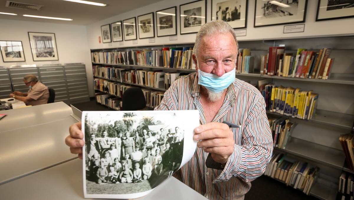 John Lynch who regularly visits the Albury library to study history through the microfiche with a photograph of a large family gathering. Picture: JAMES WILTSHIRE
