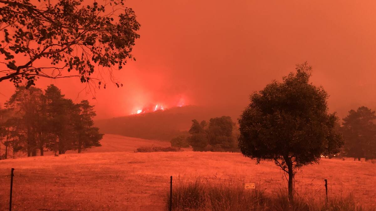 Foreboding sight: The atmosphere took on an orange glow as fire headed across the ridge at Maragle. Picture: VANESSA KEENAN